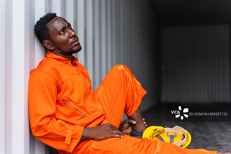 在集装箱里工作的过度劳累的黑人图片素材