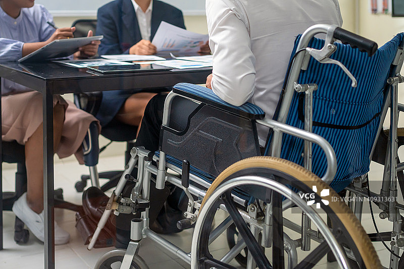 工作中的包容性：残疾专业人士与同事开会图片素材