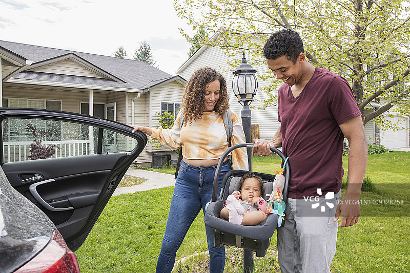 年轻父母将女儿放入汽车图片素材