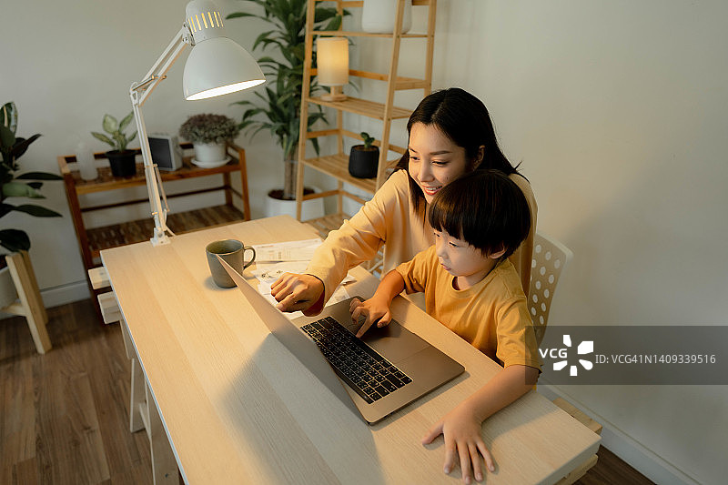 在家工作期间照顾儿子的职业母亲图片素材