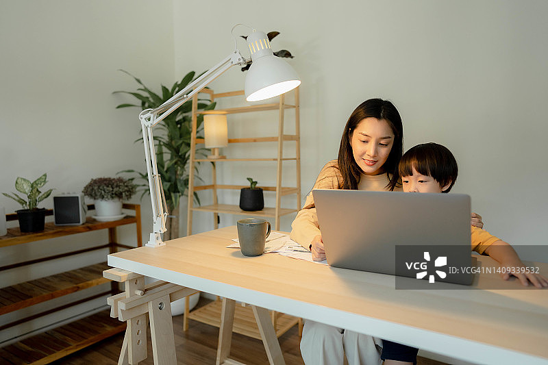 在家工作期间照顾儿子的职业母亲图片素材