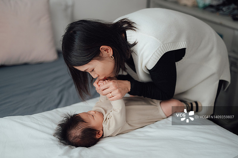 母亲在床上和女儿玩耍图片素材