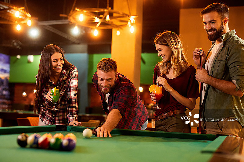 朋友们在当地的台球厅里玩台球图片素材