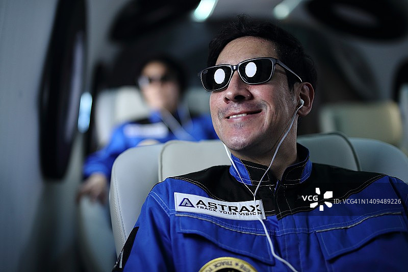 宇航员在宇宙飞船的舷窗边眺望地球图片素材