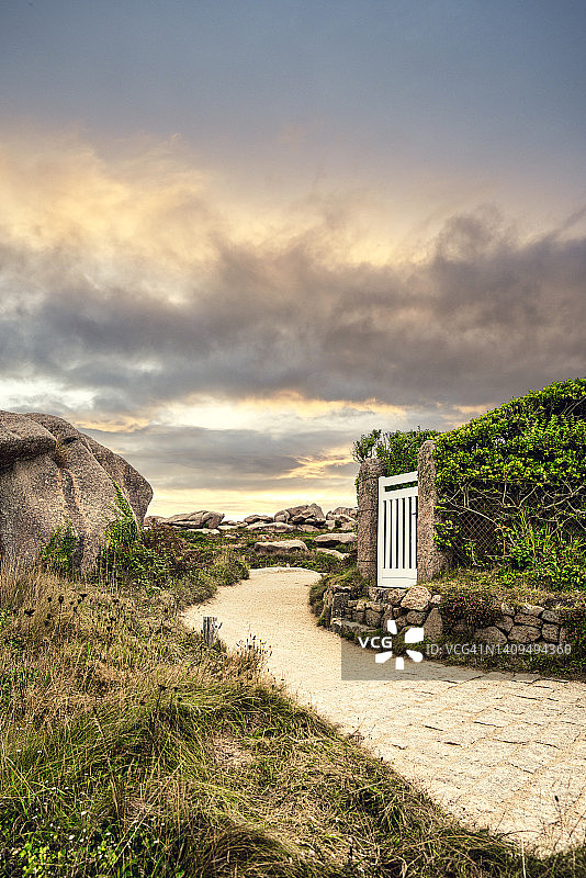 通往花园的小白门，位于法国布列塔尼岩石景观中图片素材