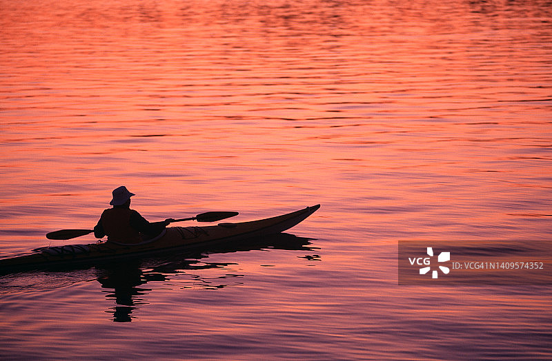 日出时划皮划艇的男人图片素材