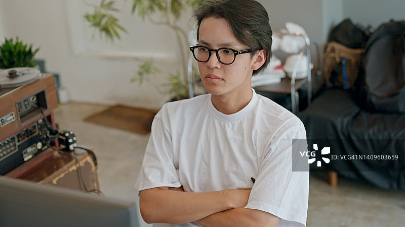 在电脑前思考的日本青年男子图片素材