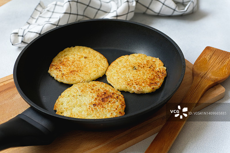 金黄土豆饼或德拉尼基在厨房的煎锅中煎炸，在家自制美味早午餐，素食概念图片素材