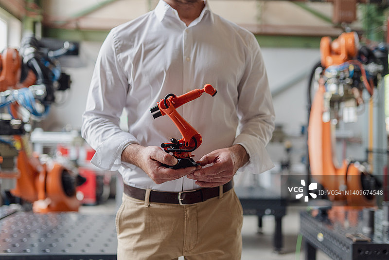 男人手持机械手臂模型的特写图片素材