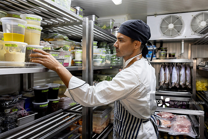厨师在餐厅工作并在储藏室寻找食材图片素材