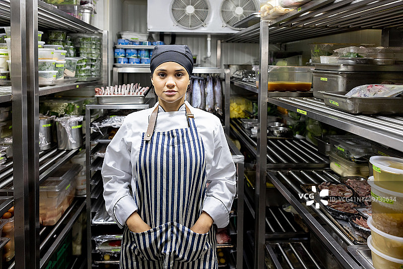 在厨房餐具室的女厨师肖像图片素材