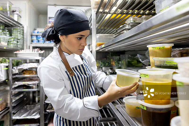 厨师在商业厨房的食品储藏室里寻找食材图片素材