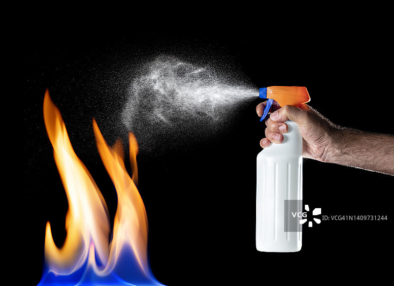 男人用灭火器扑灭屋内火灾的手图片素材