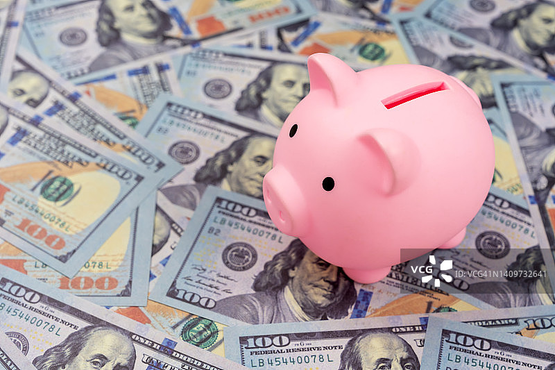 放在一堆钱上的存钱罐图片素材