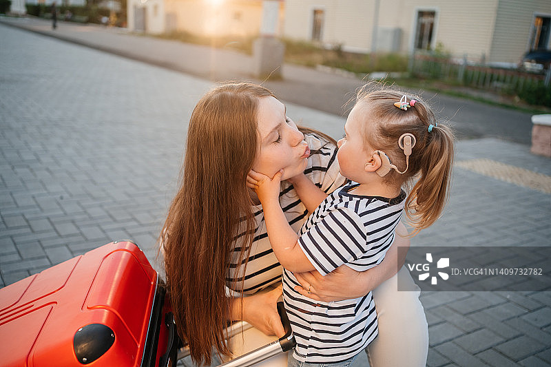 佩戴人工耳蜗的母女在站台候车图片素材