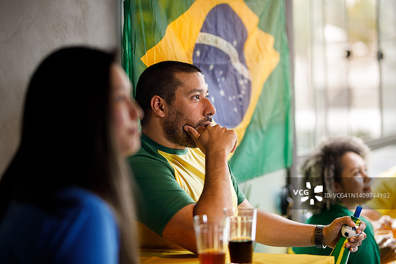 忧心忡忡的球迷在酒吧里观看巴西足球比赛图片素材