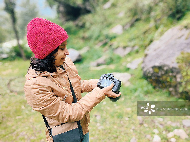女人旅行摄影师展示相机中照片图片素材