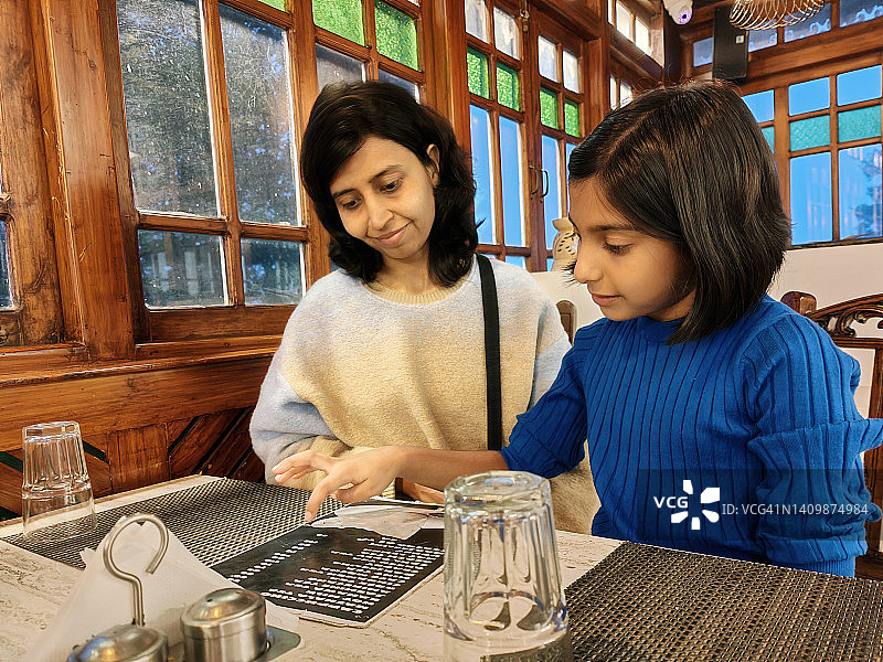 母女在餐厅看菜单图片素材