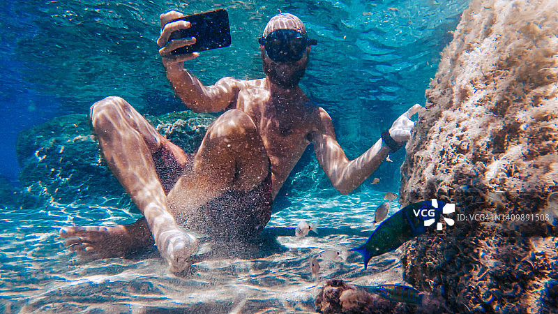 在海底与鱼群用手机自拍图片素材