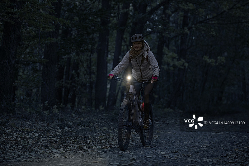 年轻女子夜晚骑电动自行车图片素材