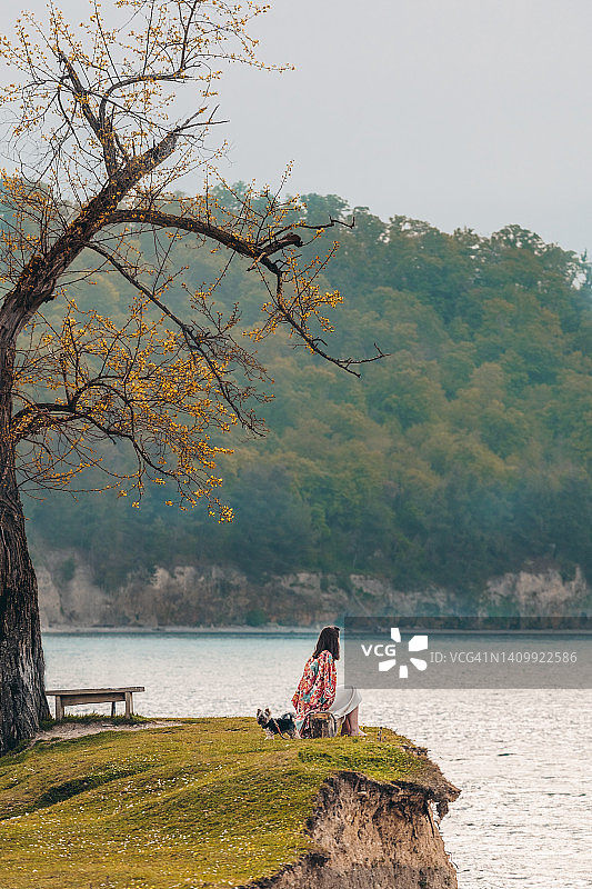 坐在海边长椅上的孤独女人图片素材