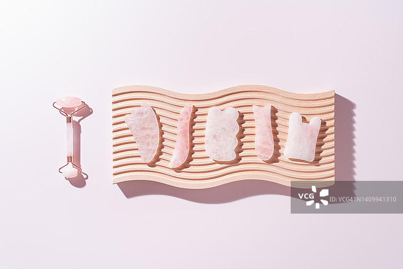 粉色水晶刮痧工具和面部滚轮图片素材