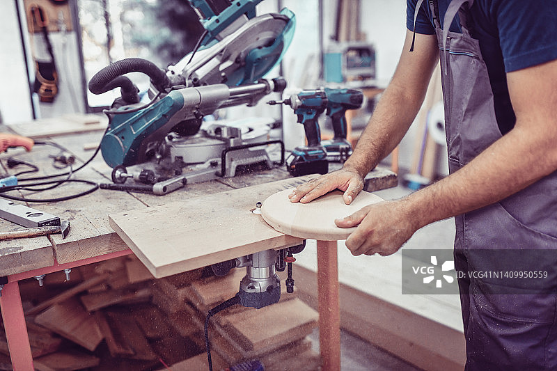 木匠在车间抛光和塑造椅子座面图片素材