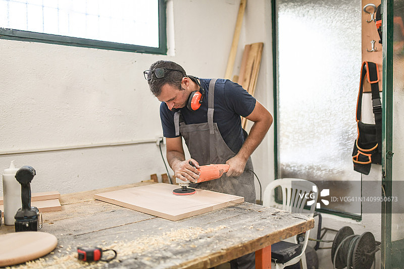木匠在车间打磨木板时产生的锯末图片素材