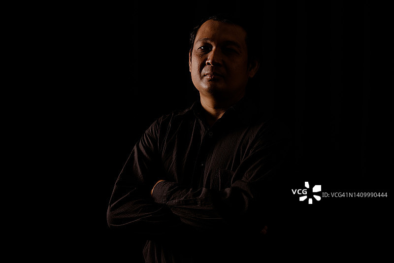 高对比度深色背景下的年轻男人肖像图片素材