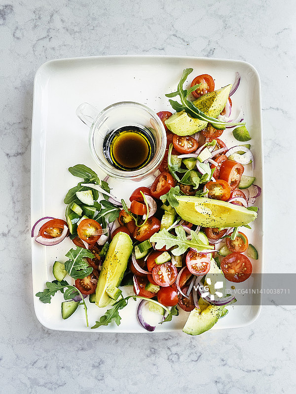 新鲜沙拉拼盘配芝麻菜牛油果番茄白色背景图片素材