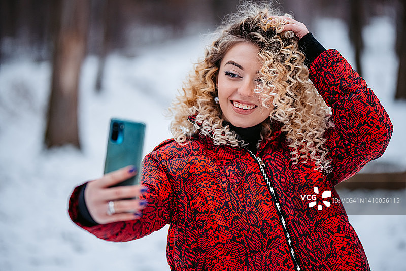 年轻女人在雪 forest 林中自拍图片素材