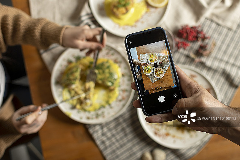 男人用智能手机在餐厅或咖啡馆拍摄食物图片素材