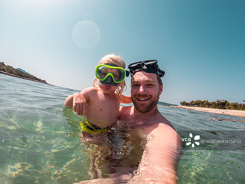 正在使用谷歌眼镜看向镜头的白人父子图片素材