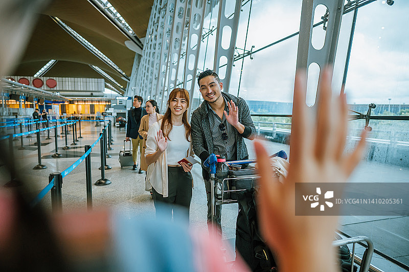 在机场到达大厅迎接父母的快乐的年轻华裔女孩图片素材