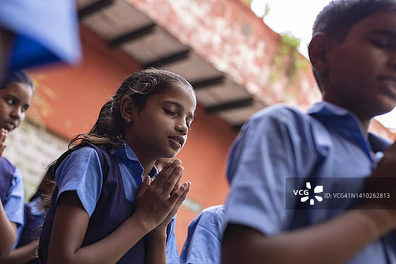 一群学生在晨会上祈祷图片素材