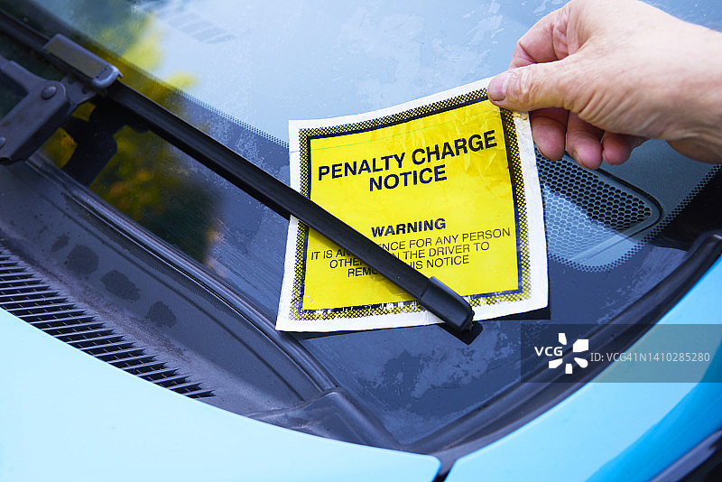 从汽车挡风玻璃上移除停车票图片素材