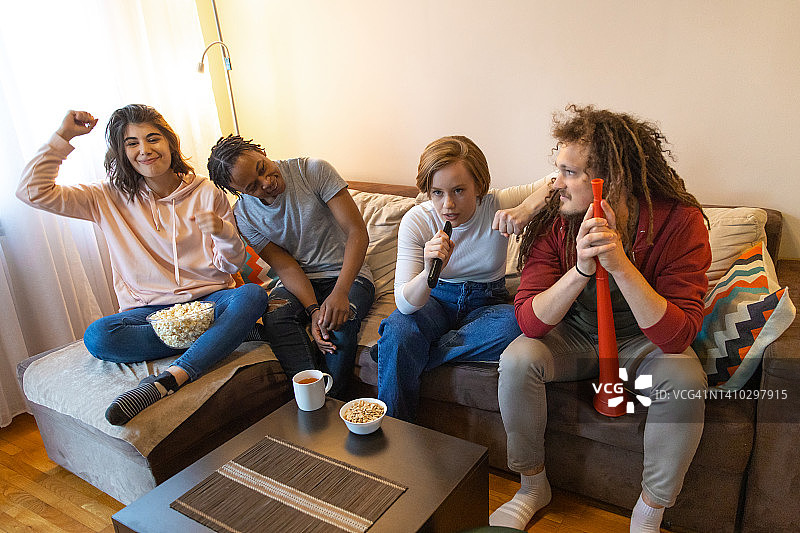 朋友们在家看电视体育比赛图片素材