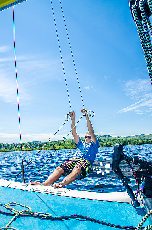 中年男人拉着绳子，推动双体船的龙骨图片素材