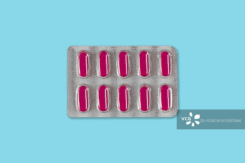 蓝色背景上粉色药丸的泡罩包装俯视图图片素材