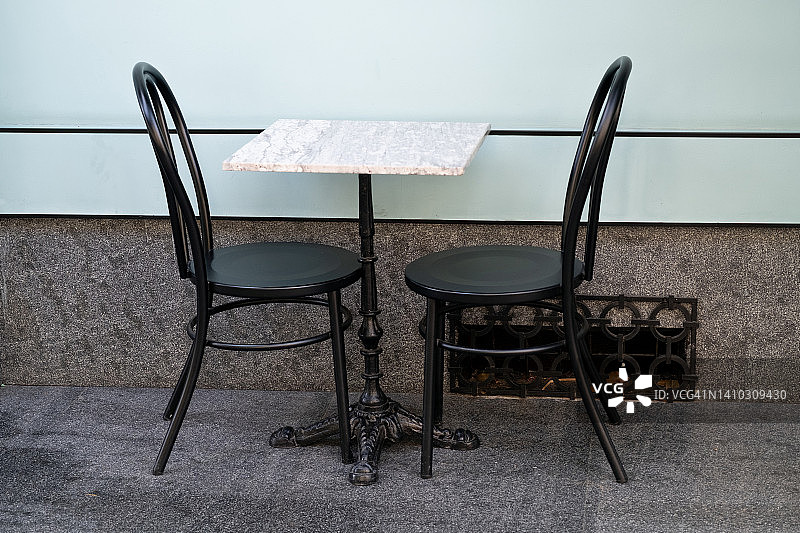 空旷的户外咖啡馆里的桌椅。时尚设计，复古风格。因新冠疫情而关闭的餐厅、户外咖啡馆。由于全球危机，没有顾客。商业问题。图片素材