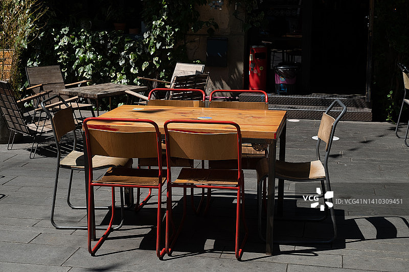 空旷的户外咖啡馆里的桌椅。时尚设计，复古风格。因新冠疫情而关闭的餐厅、户外咖啡馆。由于全球危机，没有顾客。商业问题。图片素材