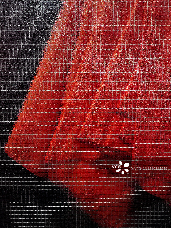 夜晚透过玻璃窗看到的红色织物纹理图片素材