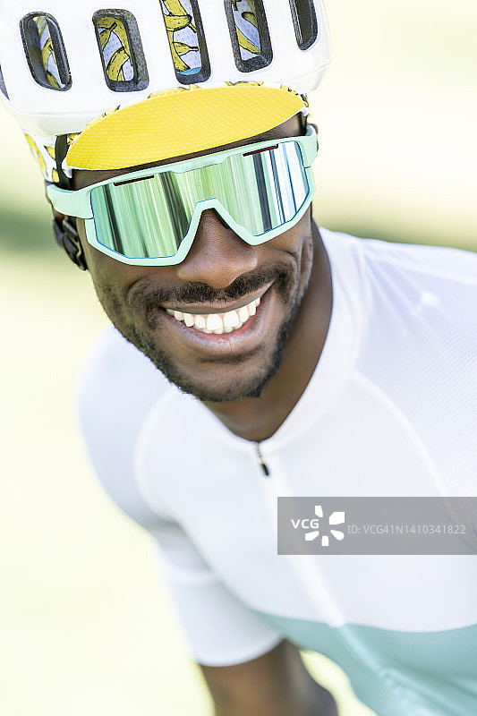 戴着自行车头盔和太阳镜的快乐骑行者图片素材