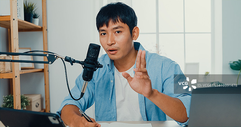 年轻男人在家中客厅用笔记本电脑录制播客图片素材