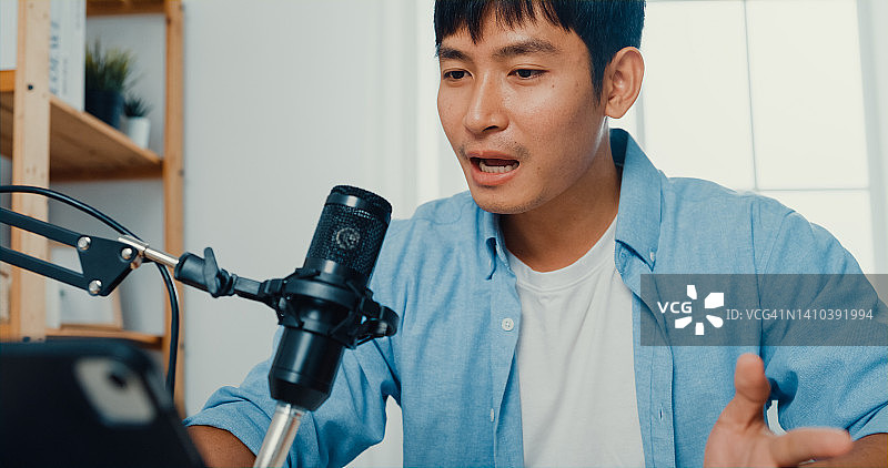 年轻男人在家中客厅用笔记本电脑录制播客图片素材