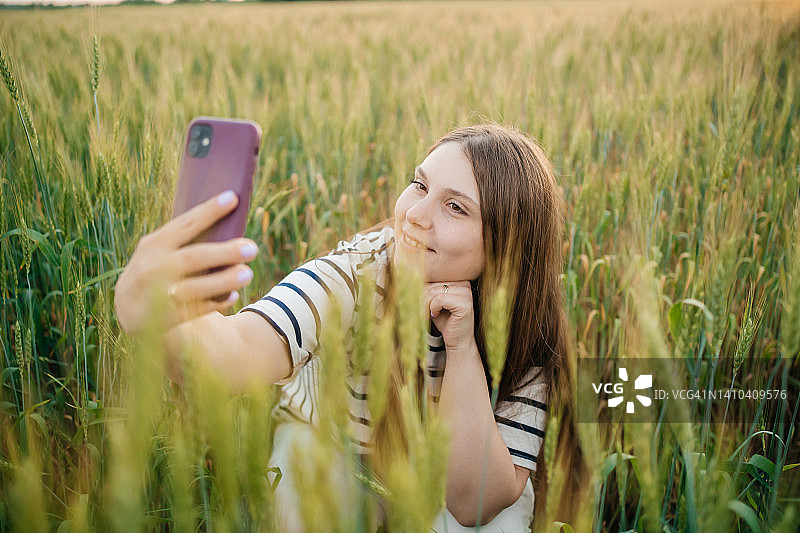 女人在麦田里进行手机视频通话图片素材