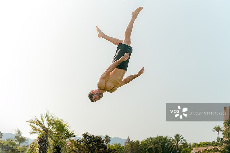 男人像超级英雄一样漂浮，翻筋斗和跳跃，特技和自由奔跑，卡波耶拉图片素材