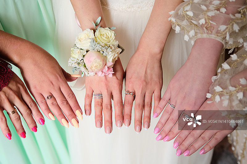 婚礼上戴着戒指的女孩和女人的手，伴娘或新娘的姐妹，单身派对，戴着珠宝和美甲的漂亮的手，婚礼日，假日，派对图片素材