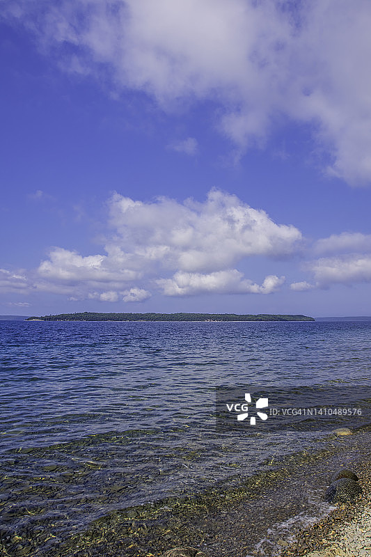 平静水域中的岩石海岸线与岛屿图片素材
