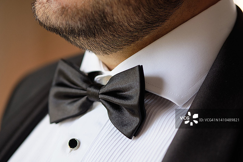 黑色领结，男士的时尚配饰，新郎或商人，特写。为婚礼日准备新郎。招待会、婚礼、晚会或派对。图片素材